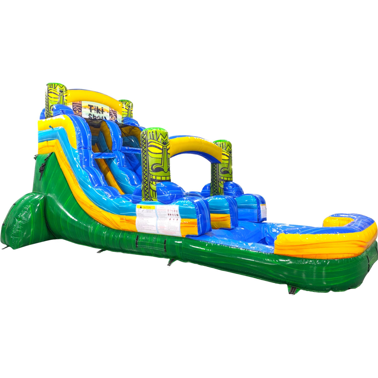 Large tropical-themed inflatable water slide featuring a single blue sliding lane, tiki mask decorations, and an extended splash pool with green base and yellow accents.