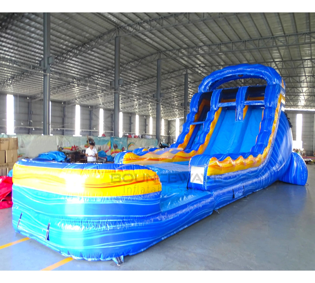 Front view of Fire and Ice hybrid water slide in indoor setting, showing tall structure with dual sliding lanes and large splash area.