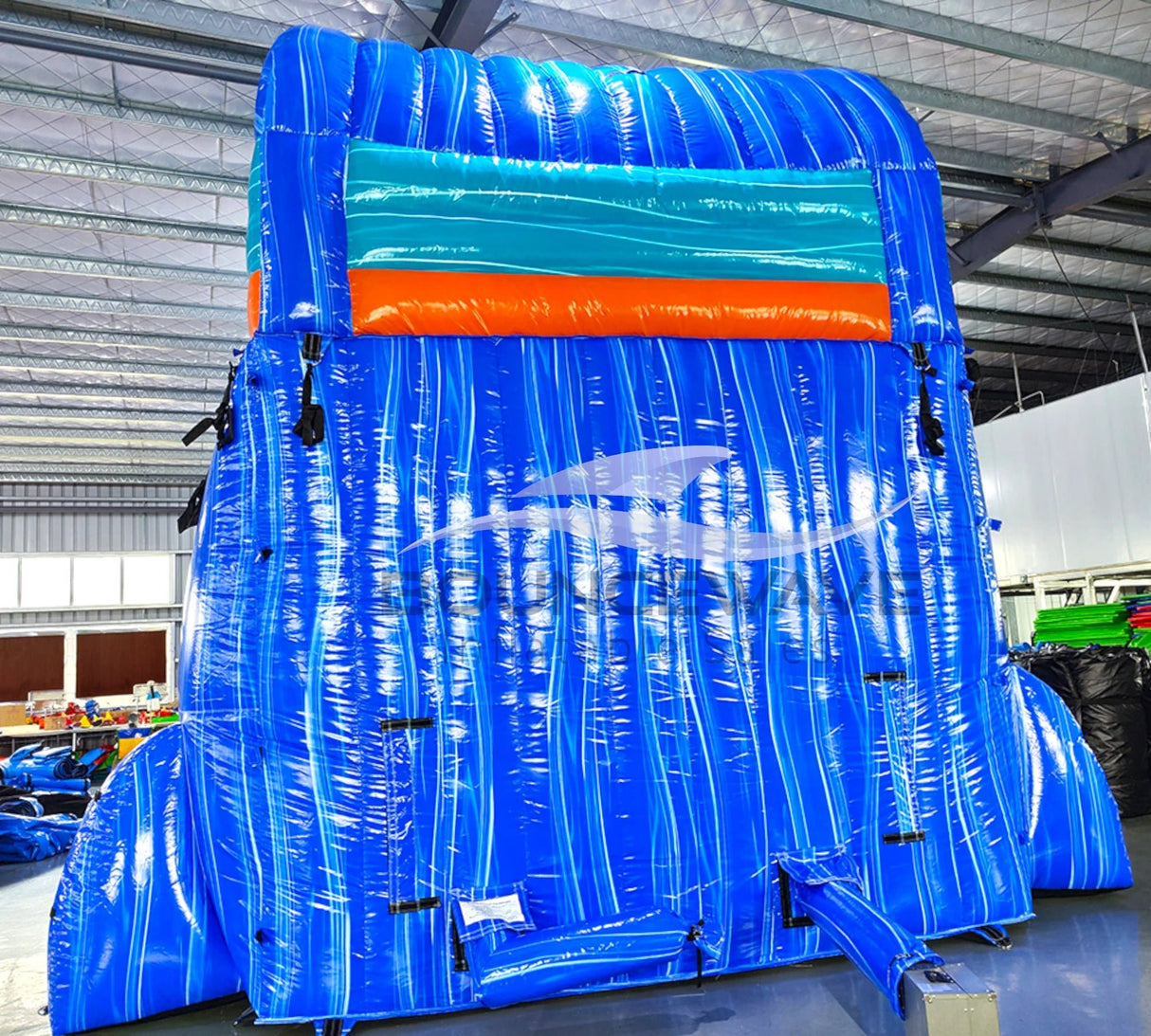 Rear view of Hammerhead Reef inflatable water slide, displaying tall blue structure with shark silhouette and climbing area.