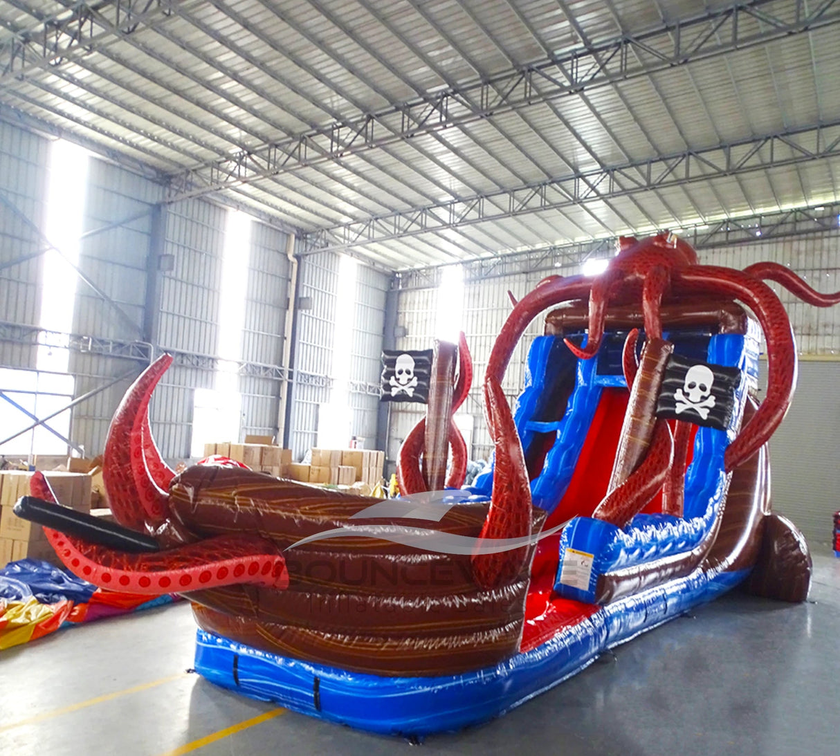 Side view of Tentacle Typhoon hybrid water slide showing pirate ship design with octopus tentacles, dual blue sliding lanes, and pirate flag decorations.