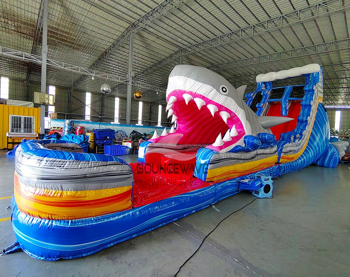20ft Rip Curl Shark Attack 2pc Hybrid Dual Lane Inflatable Water Slide showcasing shark design, dual slides, and vibrant colors in indoor facility setting