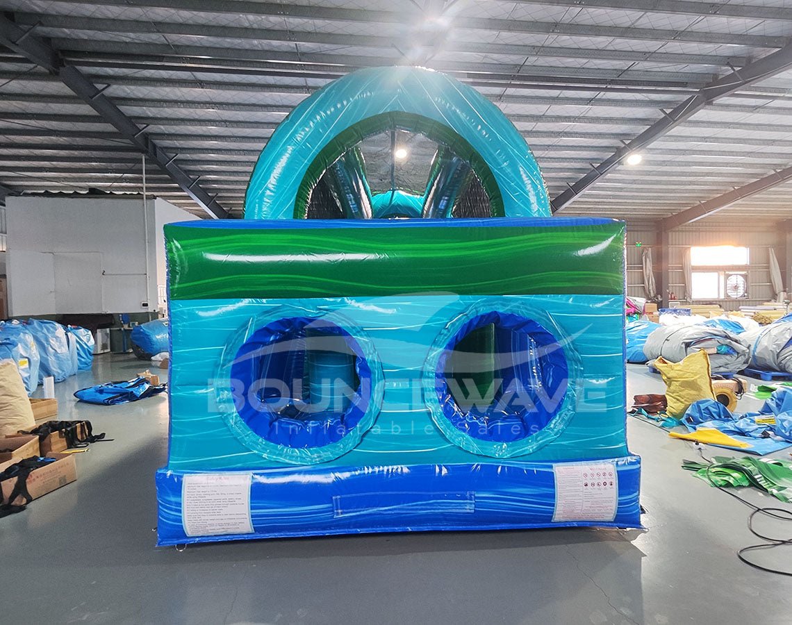 46ft Island Drop Hybrid Inflatable Obstacle Course front view showcasing vibrant blue and green colors, circular openings, and arched top in indoor facility