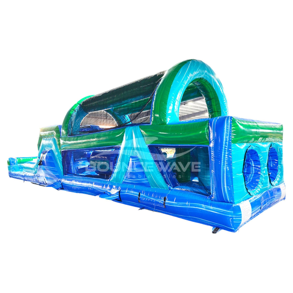 46ft Island Drop Hybrid Inflatable Obstacle Course featuring blue and green design with arched entrance, multiple obstacles, and slide in warehouse setting