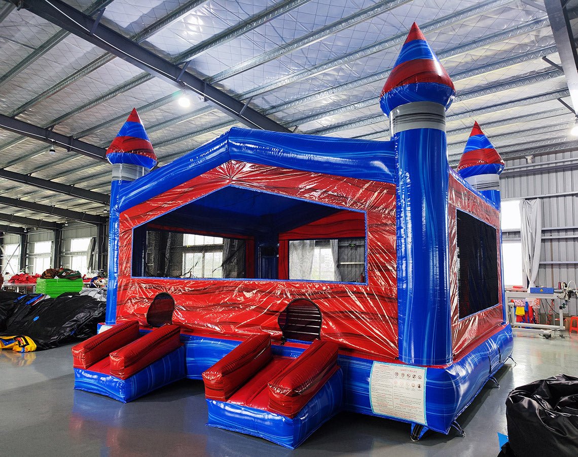 Baja XL Commercial Grade Bounce House side angle view highlighting red body, blue accents, castle turrets, and dual entrance slides with safety instructions