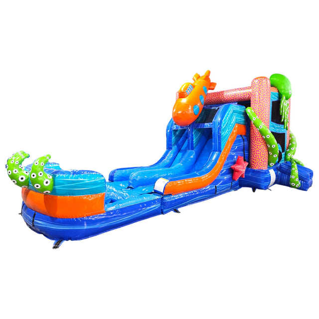 Large underwater-themed inflatable combo featuring dual blue slides, a giant orange octopus, and green tentacles. The structure includes a blue base with wave patterns, a bounce house area with mesh windows, and a splash pool. Set against a white background, showcasing its vibrant design for commercial wet/dry use.