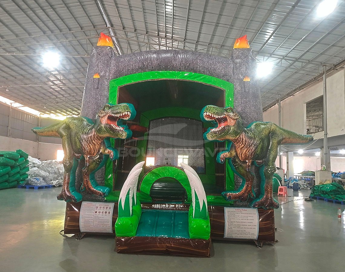 Dino Dive Commercial Grade Bounce House showcasing dual T-Rex figures, grey castle structure, and flame-topped turrets in indoor facility