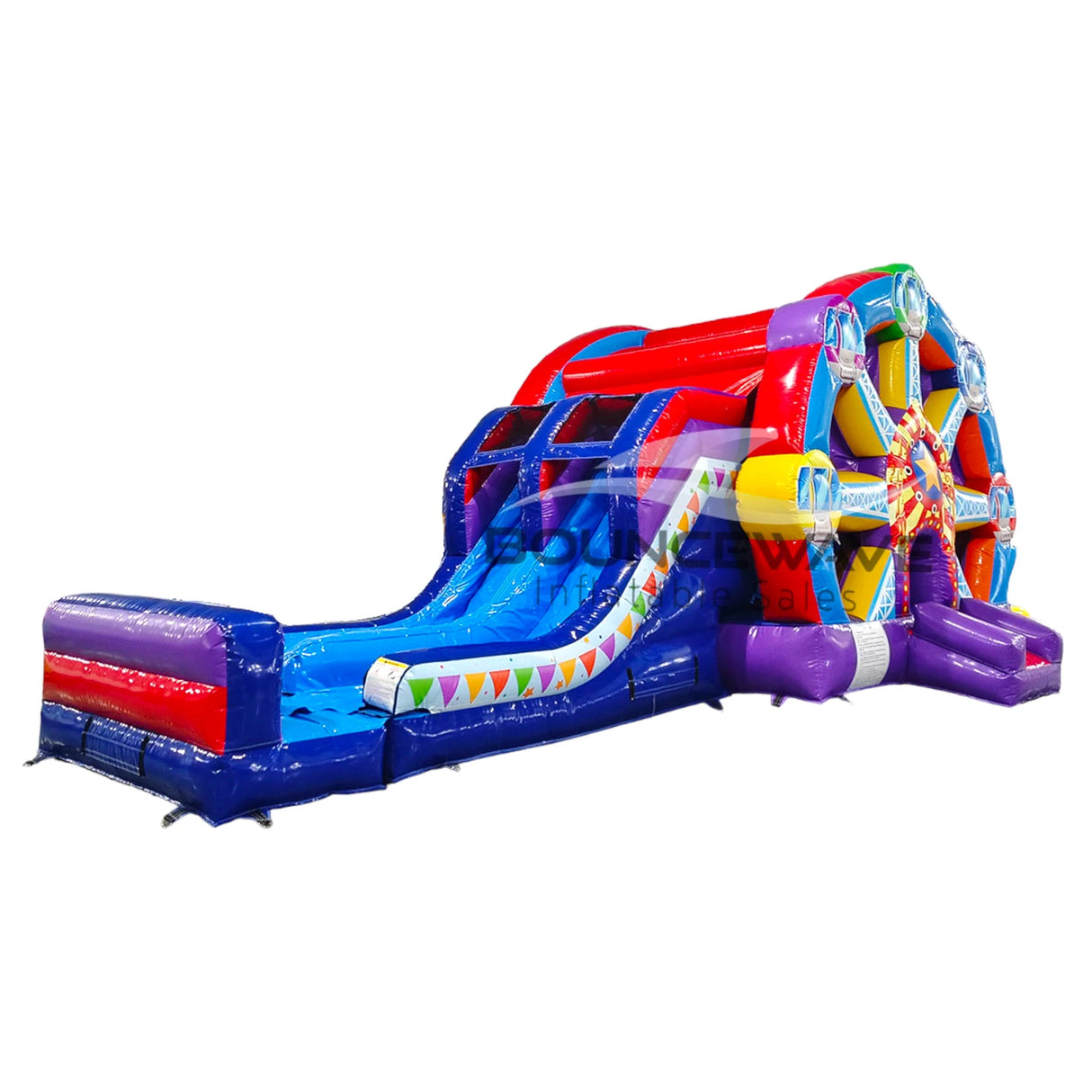 Side view of Ferris Wheel Dual Lane Commercial Inflatable Combo (Wet/Dry) isolated on a white background. Shows the full structure including the colorful Ferris wheel design, dual blue slides, and multicolored base. The inflatable features vibrant blue, red, purple, and yellow colors with a festive bunting design along the slide.