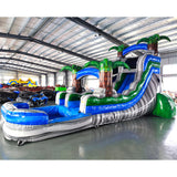 Side view of Aloha Splash single lane water slide showing full length with blue sliding surface, palm tree accents, and large splash area with wave-like patterns.