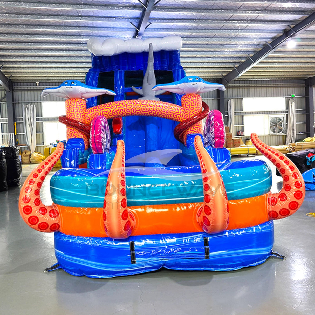 Front view of Hammerhead Reef hybrid water slide in indoor setting, showing tall structure with dual sliding lanes, shark figures, and colorful sea-life decorations.