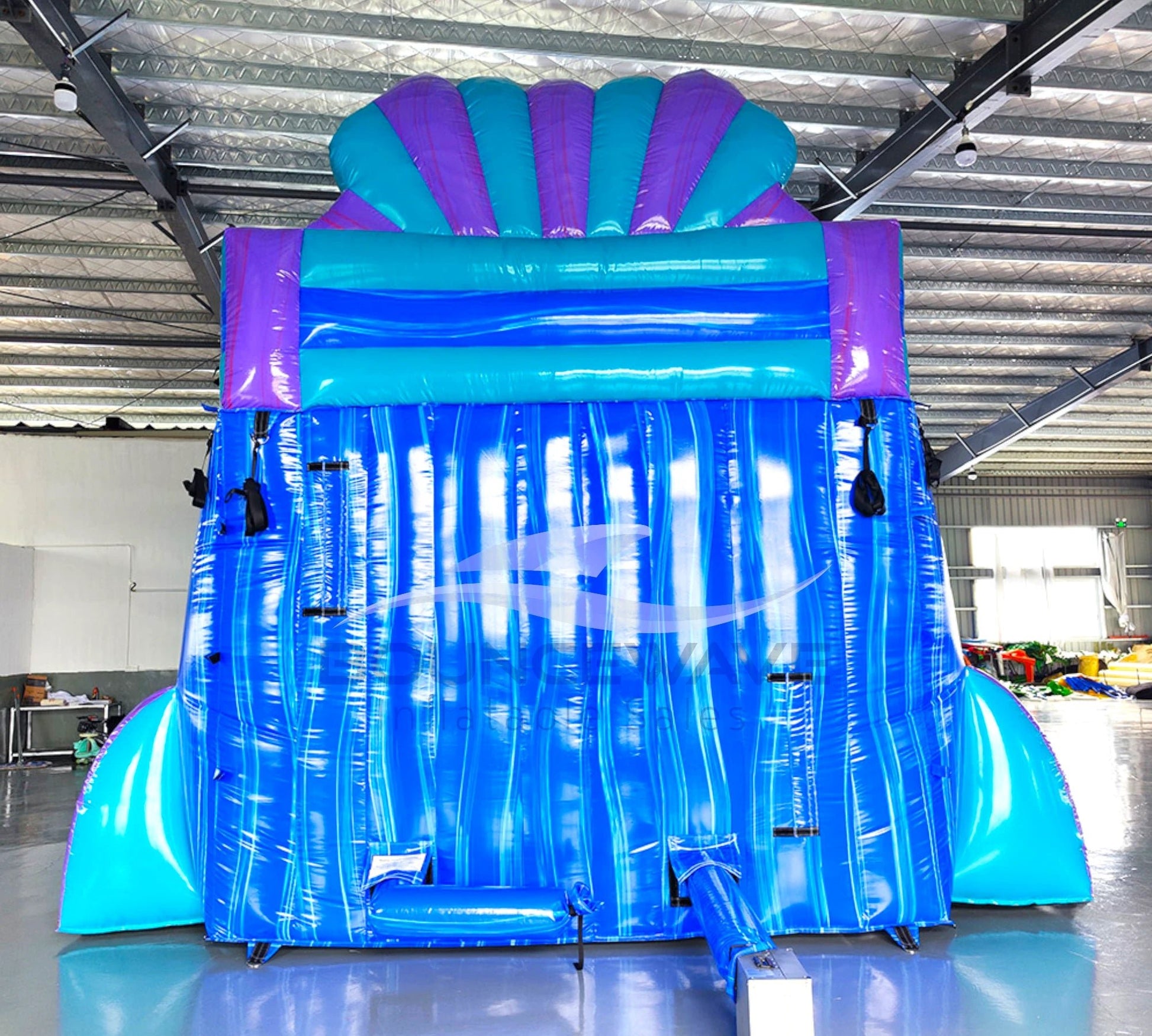 Rear view of Mermaid's Cove hybrid water slide showcasing tall blue structure with climbing area and safety features in indoor facility.