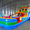 Side view of Tropical Oasis hybrid water slide in indoor warehouse, showing full length with dual sliding lanes, palm trees, and large splash area with blue and green colors.