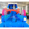 Front view of the 20ft Hammerhead Reef Hybrid DL inflatable water slide, showcasing its blue sliding lanes, shark decorations, octopus tentacles, and spacious splash pool. The slide combines open and tube slide elements, set up in an indoor warehouse with other inflatables visible in the background.