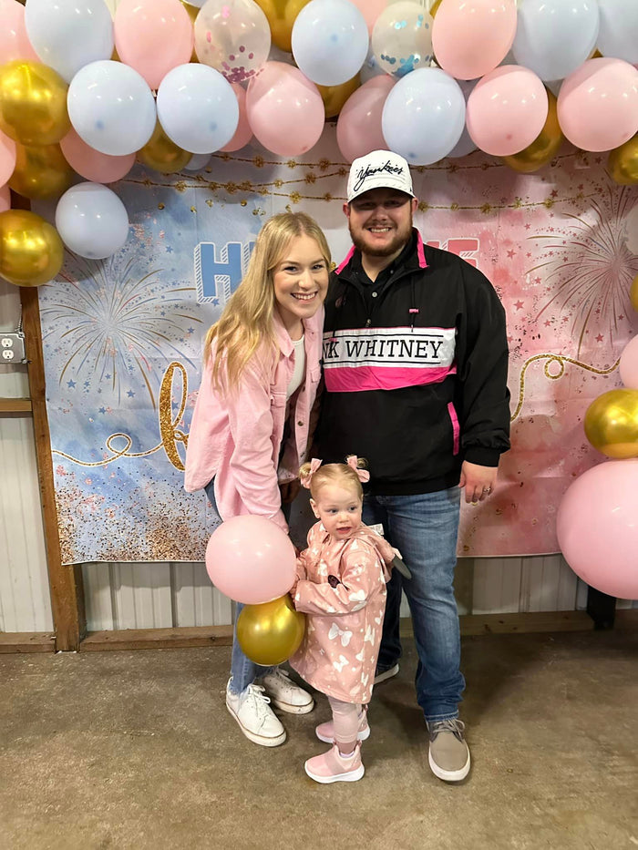 Blaine Ladd, Business Operations Director, posing with a woman at a formal event, both smiling and dressed elegantly against a backdrop of balloons