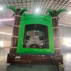 Dino Dive Commercial Grade Bounce House with tropical theme, palm trees, and inflatable dinosaurs in warehouse setting
