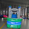 Front view of Euro Green Gush Commercial Econo Inflatable Wet/Dry Combo, showcasing the bounce house entrance with blue and silver walls, green turrets, and colorful interior. Features a green slide and splash pool area. Set up in an indoor warehouse with metal roofing visible.