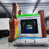Large inflatable safari-themed combo featuring two tall giraffe figures flanking a bounce house entrance. The structure has vibrant yellow, orange, and green colors with cartoon animal decorations. Includes a slide and splash pool area. Set up in an indoor warehouse with metal roofing visible.
