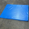 Impact Safety Mat for Inflatables displaying large blue padded surface with sewn edges on concrete floor
