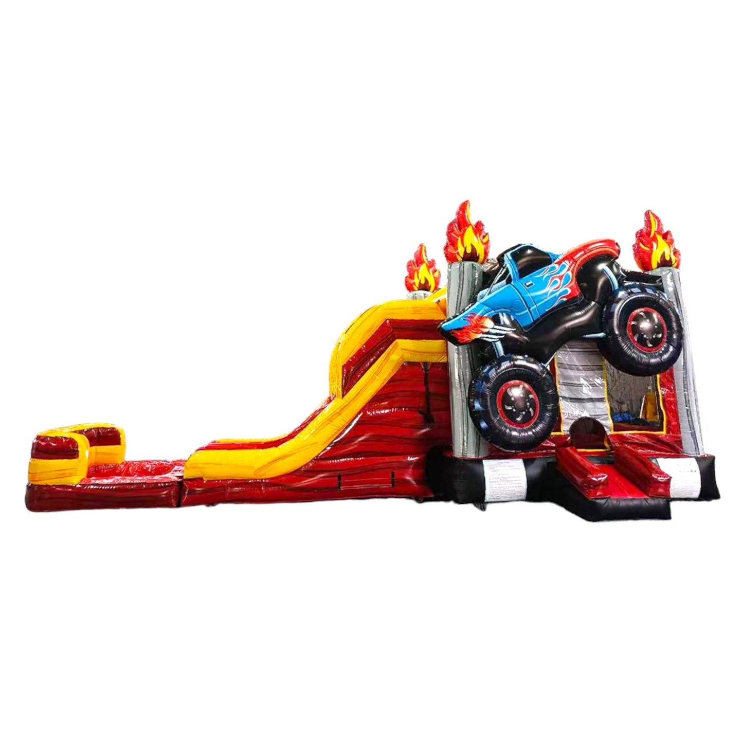 Side view of Monster Truck Dual Lane Commercial Inflatable Combo featuring a blue monster truck with flame decals mounted on top of a red and yellow base. The structure includes dual slides, one red and one yellow, leading to a splash pool area. Set against a white background, showcasing its design for commercial wet/dry use.
